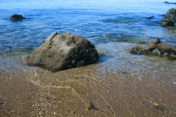 ゴツゴツした岩の潮溜りの透き通った青い海