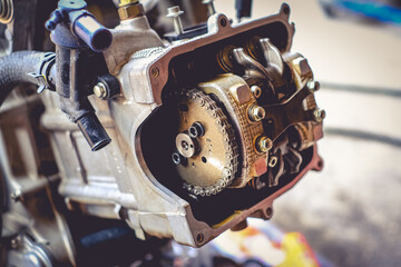 The mechanic is setting the valve on the motorcycle engine.	