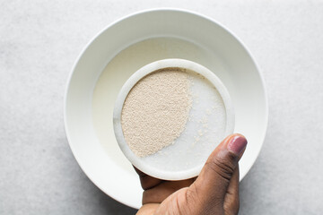 Overhead view of instant yeast on a white tray, yeast granules for baking bread