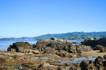 ゴツゴツした岩の潮溜りの透き通った青い海