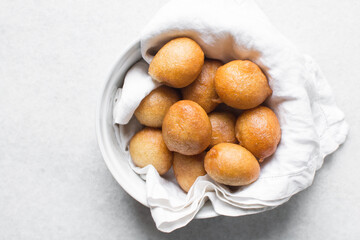 Homemade nigerian puff-puff on a white bowl, nigerian fried dough balls, fresh homemade bofrot on white dish
