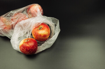 A bag of apples is sitting on a black background