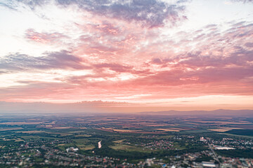 Bird's eye view of the sunset. Below are fields and villages against a dramatic, beautiful sky.