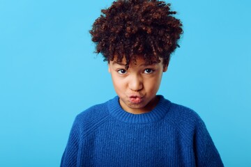 Excited young african american girl expressing surprise with wide open mouth against bright blue background