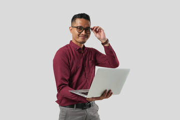 A young handsome Asian man in a suit wearing glasses and making various facial expressions and holding a laptop.