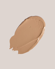 Makeup foundation, beige concealer swatch smudge smear on beige background. BB CC cream texture