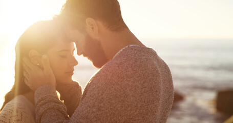 Couple, forehead kiss and hug on beach together for romantic sunset, bonding in nature and love,...
