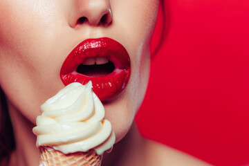 Close-up sexy woman lips with glossy red lipstick eating a creamy ice cream. Pleasure of eating. Beauty make-up studio shot.
