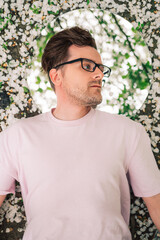 Creative male portrait with mirror in blooming apples spring garden