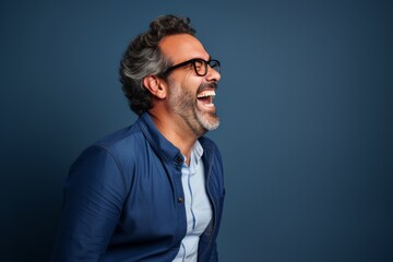 Obraz premium Portrait of a glad man in his 40s laughing while standing against plain cyclorama studio wall