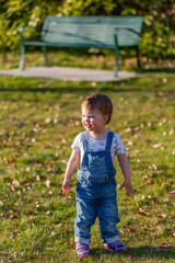 Toddler girl plays in a park in autumn; North Vancouver, British Columbia, Canada