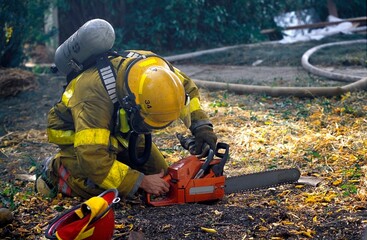 Fototapeta premium Fireman Starting Chainsaw