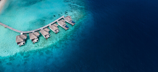 vacations in Maldives, aerial view of beautiful hotel villas on turquoise water beach, luxury resort, banner background with copyspace