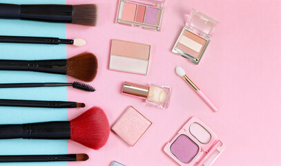 makeup brushes and eye shadow on a colored background