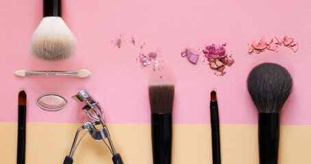 makeup brushes and eye shadow on a colored background