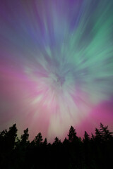 Aurora Borealis rays spreading from auroral corona point creating night sky filled with pastel colors of northern lights