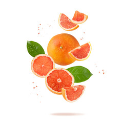 Fresh grapefruit fruit whole and slices with leaves and drops falling flying
