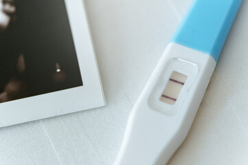 diabetes, patient, medical, medicine, fertility, birth, check, pregnancy, exam, analyzing. A pregnancy test is on a table next to a picture of a baby. as the test would indicate that is pregnant.