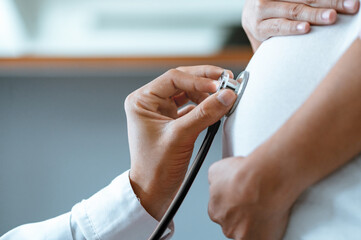 checkup, assistance, clinical, patient, exam, examining, healthcare, heartbeat, stethoscope, specialist. A doctor is checking a pregnant woman's belly. The doctor is wearing a white lab coat.