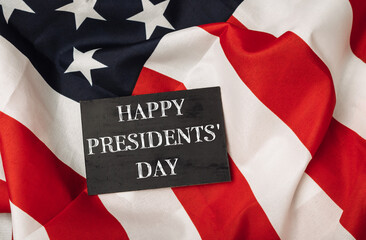 A black sign with the words Happy Presidents' Day written on it is placed on top