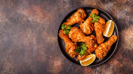 Fried chicken legs with lemon and parsley.