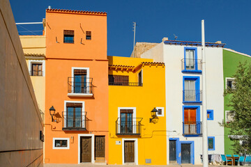 View to beautiful narrow Villajoyosa street with multi-colored houses. La Vila Joiosa - coastal...