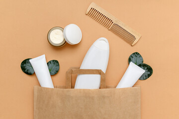 White plastic container for shampoo and a wooden comb with Kraft bags.