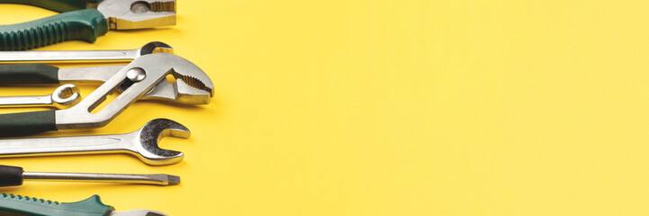 Work tools on bright yellow background banner. Panoramic web header. Wide screen wallpaper.