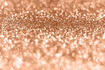Peach fuzz sparkling glitter bokeh background, abstract defocused texture. Holiday lights