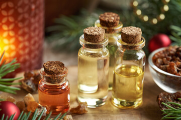 Christmas selection of essential oils with frankincense, myrrh, candle and spruce tree
