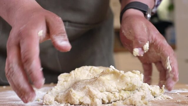 a male chef prepares the dough for making kutab