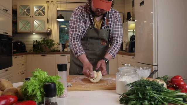 a male chef prepares the dough for making kutab