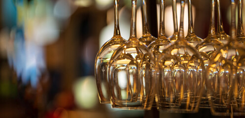 Wine glasses hanging from a rack with copy space