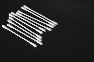 heap of cotton buds on black background top view, copy space