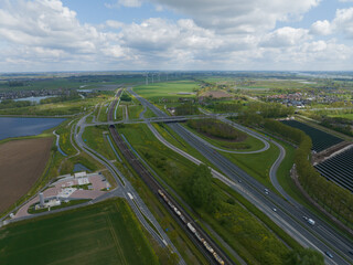 Fototapeta premium Transportation and mobility on the infrastructure of The Netherlands. Crossing of roads highways, asphalt road and green landscape. The Netherlands. Aerial drone view.