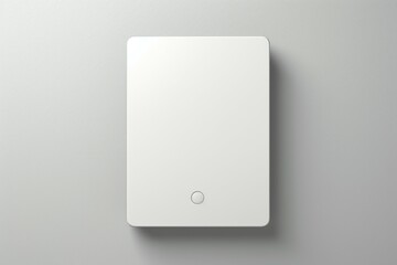 Single, white modern light switch with a simple design on a smooth gray wall