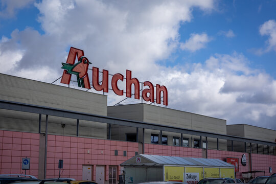 Wroclaw, Poland - February 19, 2022: French supermarket Auchan red logo on top of the shopping centre building. 
