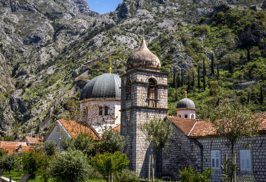 Kotor, Montenegro - April 29, 2022: A view to Saint Nicolas church in Kotor old town. Rocky mountains in background. 
