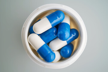 Blue and white capsules in a jar close-up.