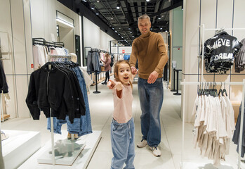 Father and Daughter Shopping in a Modern Clothing Store During the Day
