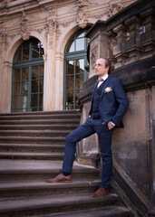 Groom on his wedding day. Stylish, elegant groom stands on the steps
