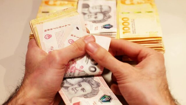 hands counting the new argentine banknotes of 10000, 2000 and 1000 pesos, symbol for Argentina's inflation