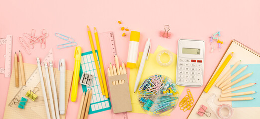 stationery items for girls or women on light pink background. Back to school. Female Student's, pupil's or engineer's supplies. Office objects on pastel pink background. Calculator, pen, pencil etc.