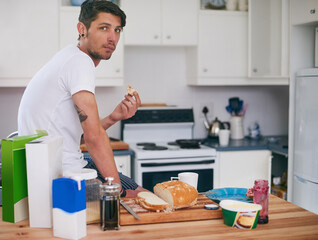 Man, portrait and eating with breakfast in kitchen for morning meal, snack or food at home. Young...