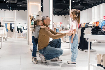 Father Shopping With His Two Daughters in a Modern Clothing Store During Weekend