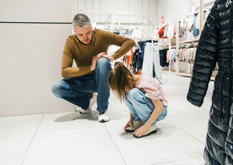 Father and Daughter Shopping for Clothes at a Busy Retail Store in the Afternoon.