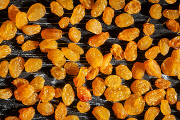 yellow raisins pattern on black wood background