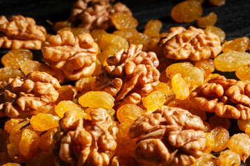 walnuts raisins on black wood background
