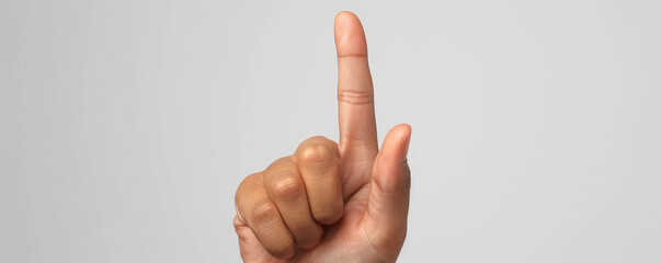 Close-up of a hand with one finger raised against a plain grey background. Excellent for concepts of communication, counting, or signaling. - Powered by Adobe