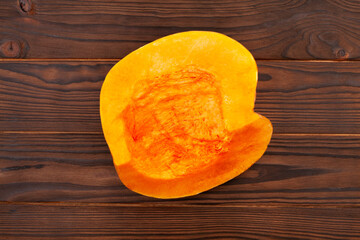 sliced pumpkin on wood background top view